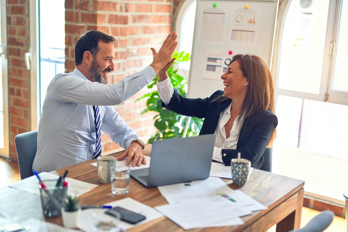 Two business colleagues celebrating a deal